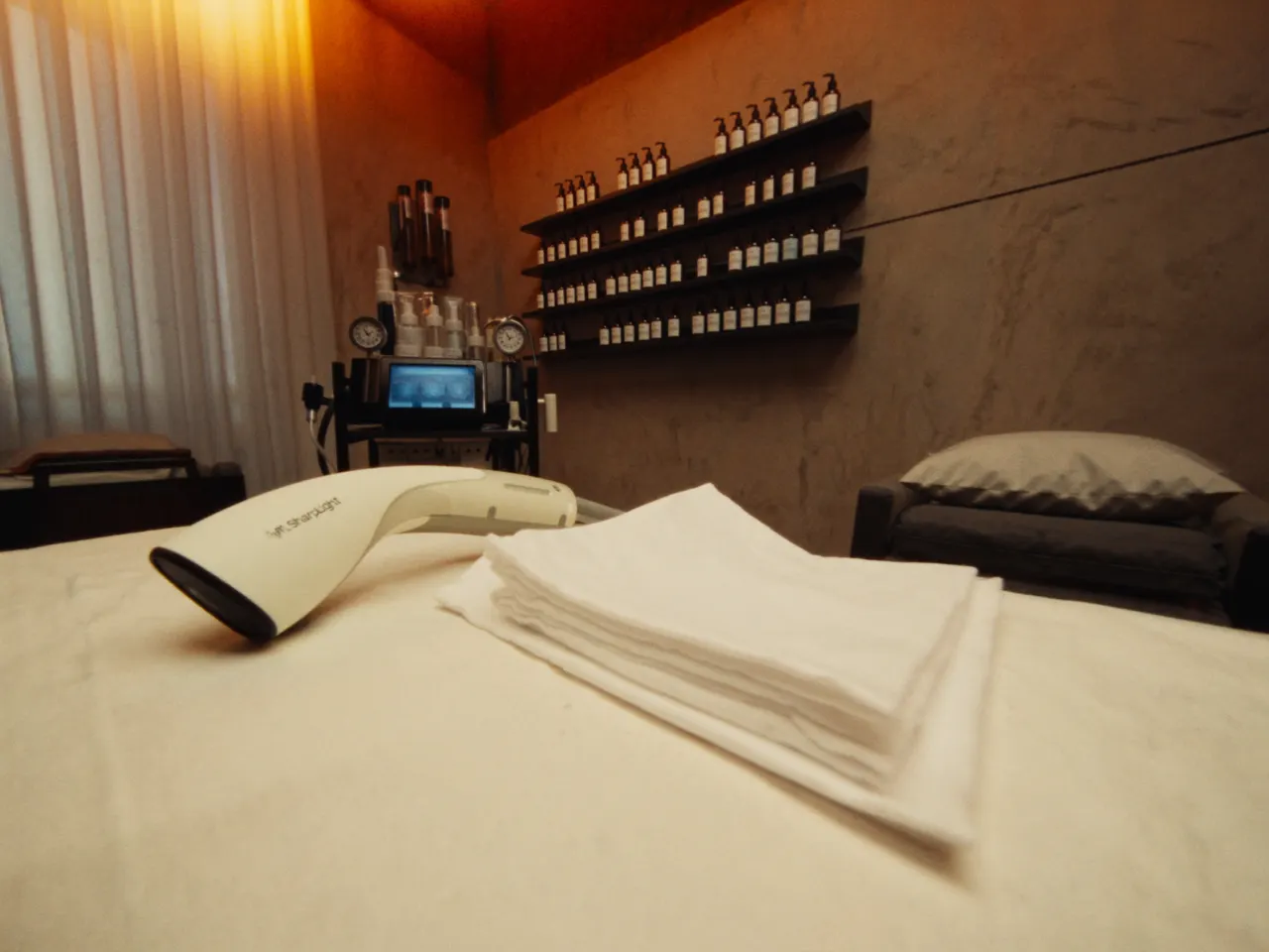 SharpLight laser handpiece on a treatment bed at Luxury Cosmetic Med Spa